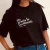 Detalle del estampado De gracia lo recibisteis, Mateo 10:8, en blanco sobre camiseta negra de algodón orgánico