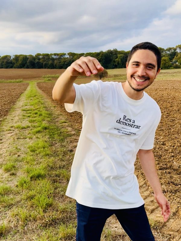Camiseta Res a demostrar — retrato Hombre sonriendo con la camiseta cristiana Res a demostrar en un campo